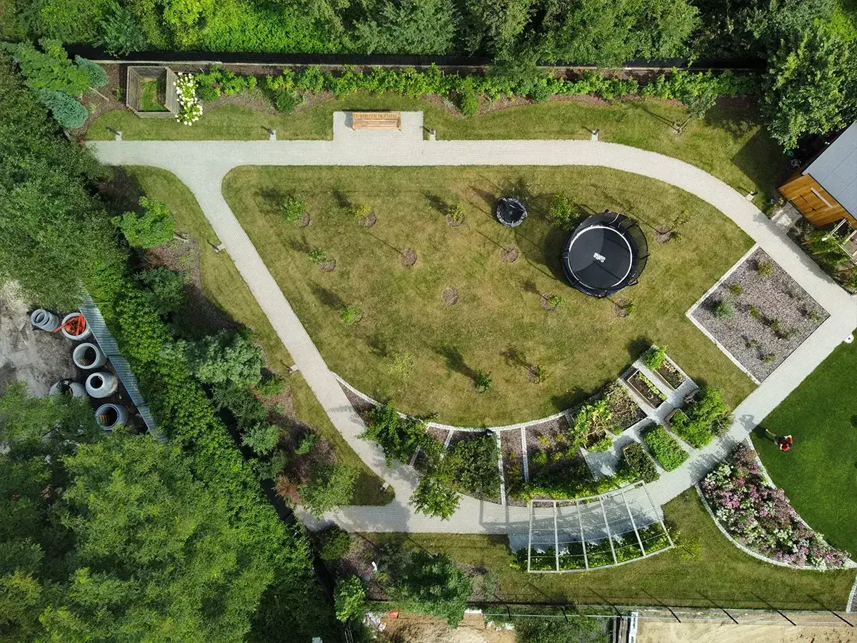 Piękny ogród z trampoliną i grządkami warzywnymi, zajmujący pewnie nie jeden hektar.